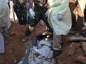 ثوار ومسؤولون صحيون ينتشلون جثثا من قبر جماعي في طرابلس ي