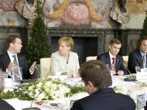 الرئيس الروسي (إلى اليسار) يتحدث الى المستشارة الالمانية خلال مأدبة غداء في هانوفر 
