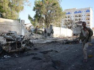 صومالي يمر قرب موقع تفجير سيارتين امام فندق قرب مجمع للامم المتحدة في مقديشو في الاول من كانون الثاني/يناير 2014
