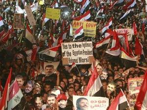 اعضاء من جماعة الاخوان المسلمين وانصار الرئيس المعزول محمد مرسي يضعون اقنعة لمرسي ويلوحون بالاعلام المصرية في ميدان رابعة العدوية في القاهرة
