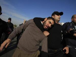 شرطي يعتقل احد مؤيدي الرئيس المصري المعزل محمد مرسي خارج قاعة محاكمته في القاهرة 