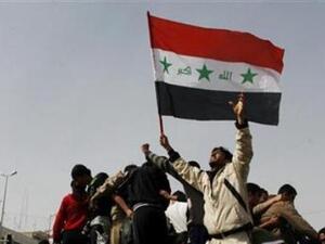 عراقيون يرفعون علم بلادهم أثناء احتجاج في الموصل 
