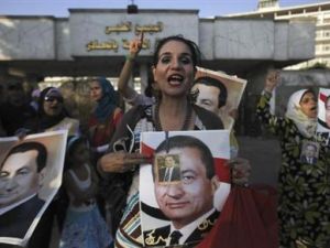 امرأة ترفع صورة حسني مبارك امام مستشفى المعادي العسكري بعد نقله إليها يوم الخميس
