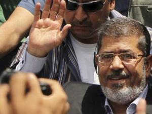 ارشيف/ مرسي يلوح بيده لمؤيديه