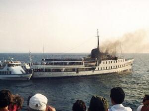 مارة ينظرون الى السفينة "سيتي اوف بوروس" والدخان يتصاعد منها في 11 تموز/يوليو 1988
