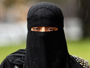 A woman wears a full face Niqab.