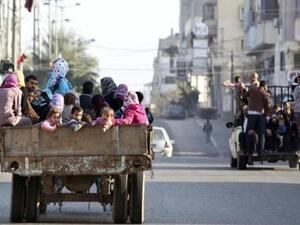 فلسطينيون فروا من منازلهم يركبون على ظهر شاحنة في طريقهم لمدرسة تديرها الامم المتحدة في مدينة غزة
