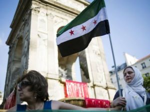 متظاهرة ضد النظام السوري ترفع العلم السوري ما قبل حكم البعث في باريس 
