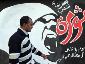 رجل يمر برسم عن الثورة على جدران في شارع محمد محمود قرب ميدان التحري