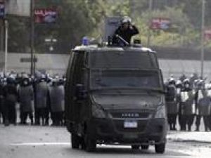 أفراد من الشرطة المصرية ومدرعة يطلقون الغاز المسيل للدموع على متظاهرين فوق جسر قصر النيل المؤدي لميدان التحرير بالقاهرة
