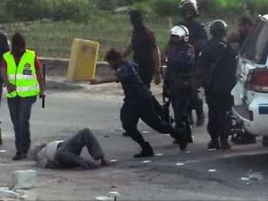 ارشيف/ رجال شرطة يعتدون بوحشية على متظاهر ملقى على الارض خلال قمع تظاهرات في المنامة عام 2011