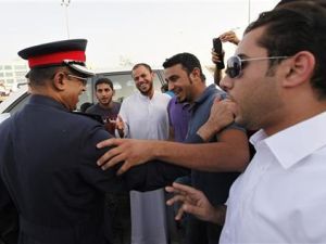 شرطي يتحدث مع محتجين لمنعهم من القيام بمسيرة اثناء مظاهرة امام مقر حزب الوفاق 
