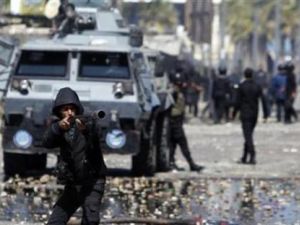 شرطي يطلق غازا مسيلا للدموع على محتجين مناهضين للرئيس المصري محمد مرسي أثناء اشتباكات بين الطرفين في بورسعيد
