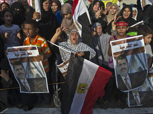 Supporters of deposed Egyptian president Mohamed Morsi (portrait) cheer during a football match between the two main Cairo protest camps by members of the Muslim Brotherhood and backers of the ousted Islamist leader set up at the Nahda and Rabaa al-Adawiya squares (AFP/KHALED DESOUKI)