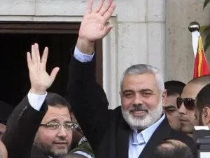 رئيس الوزراء المصري هشام قنديل (الى اليسار) واسماعيل هنية يلوحان للمواطنين في غزة يوم الجمعة