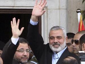 رئيس الوزراء المصري هشام قنديل (الى اليسار) واسماعيل هنية يلوحان للمواطنين في غزة يوم الجمعة