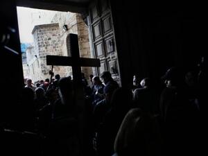 حجاج مسيحيون يدخلون كنيسة القيامة رافعين صلبانا
