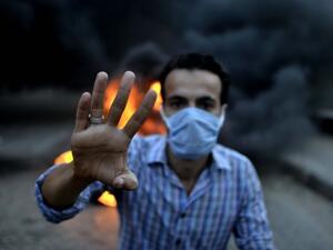 An Egyptian protestor shows his four fingers symbolising the Rabaa al-Adawyia mosque sit-in during clashes between supporters of the Muslim Brotherhood and Egypt's ousted president Mohamed Morsi and security forces, in Cairo. (AFP)