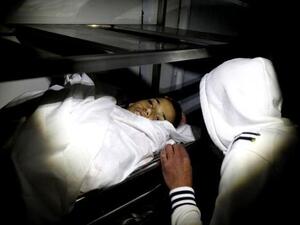 احد اقارب الفتى الفلسطيني وجيه الرمحي يلقي نظرة على جثته في مخيم الجلزون بالضفة الغربية
