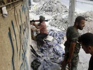 مقاتل من الجيش السوري الحر يحمل قذيفة صاروخية في احد شوارع حلب
