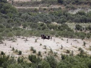 اشخاص ينتظرون العبور الى تركيا في منطقة قروية على الجانب السوري من الحدود بين سوريا وتركيا 

