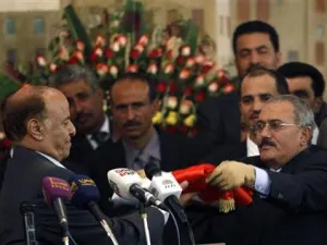 الرئيس اليمني الجديد عبد ربه منصور هادي (الى اليسار) يتسلم العلم اليمني من سلفه الرئيس السابق علي عبد الله صالح في احتفال بصنعاء يوم الاثنين
