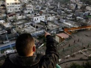 فلسطيني يشير إلى المخططات الاستيطانيّة في حي سلوان