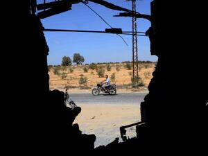 Four people died in a bomb that targeted an Egyptian intelligence facility in Sinai on Wednesday. Here, a man is seen riding his motorbike through a wall that was destroyed by an attack by Egyptian Army in the Sinai peninsula. (AFP)