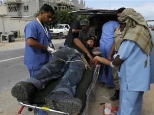 مسعفون يعالجون مقاتلا مناهضا للقذافي اصيب في القتال في وسط سرت 
