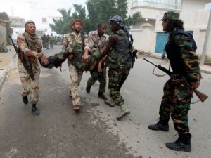 مقاتلون موالون للمجلس الانتقالي الليبي يخلون رفيقا لهم اصيب على الجبهة في سرت 
