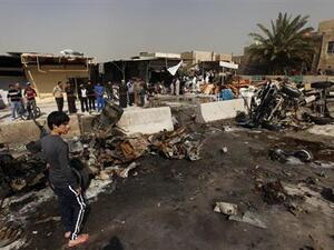 اشخاص يتجمعون في موقع هجوم بقنبلة في بغداد يوم 17 فبراير شباط 2013. 