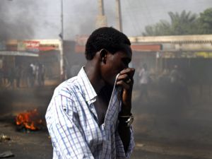 سوداني يغطي انفه اتقاء للدخان الكثيف المنبعث من اطارات محترقة في احد احياء الخرطوم 