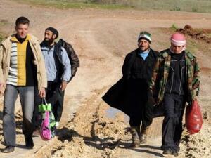 Syrian refugees walk down a dirt track in Antakya, Turkey, shortly after crossing into the country from Syria.