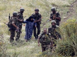 جنود سوريون يسلمون سيدة سورية مسنة الى الجيش اللبناني بعد محاولتها العبور الى شمال لبنان من منطقة العريضة السورية لملاقاة عائلتها
