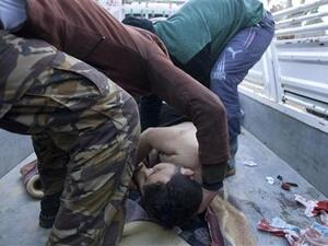 عنصران من الجيش السوري الحر يحملان جثة محتج قتل خلال مظاهرة في القصير
