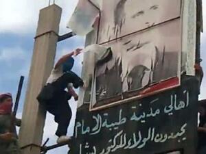 صورة من موقع يوتيوب تظهر متظاهرين يمزقون صورة للرئيس بشار الاسد 
