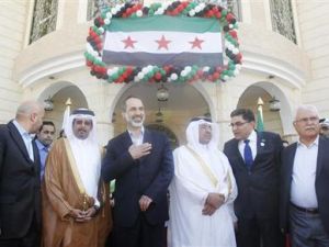 معاذ الخطيب (في الوسط) يحيي المشاركين في افتتاح سفارة الائتلاف الوطني السوري المعارض بالدوحة 