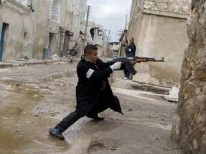 A Syrian rebel aims his weapon during clashes with government forces in the streets near Aleppo international airport in northern Syria on Monday (Photo: AFP/Stephen J. Boitano) - Picture used for illustrative purposes -