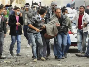 محتجون مصريون يحملون زميلا لهم أصيب في الاشتباكات بميدان التحرير
