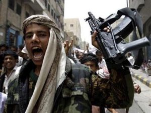 يمني من المعارضين للحكومة يرفع سلاحا ويردد هتافات مناهضة للحكومة أثناء مظاهرة في تعز 
