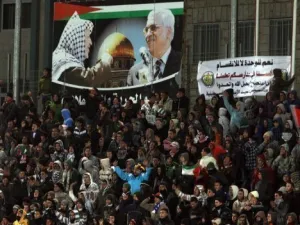 مشجعون يتابعون مباراة في كرة القدم بين منتخبي فلسطين وتايلاند في الرام
