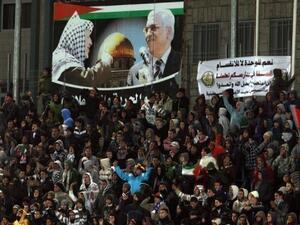 مشجعون يتابعون مباراة في كرة القدم بين منتخبي فلسطين وتايلاند في الرام
