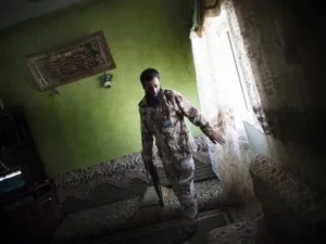 مقاتل موال للمجلس الانتقالي يقوم بتفتيش احد المنازل في حي بو سليم في طرابلس 
