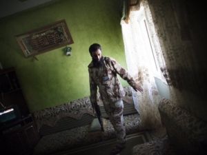 مقاتل موال للمجلس الانتقالي يقوم بتفتيش احد المنازل في حي بو سليم في طرابلس 
