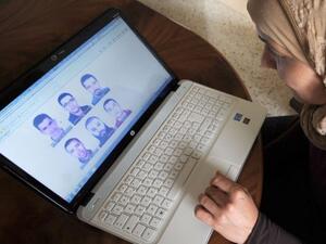 تونسية تطالع صورا منشورة على الانتترنت للمشتبهين في اغتيال بلعيد