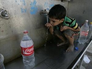 طفل فلسطيني يجلس امام صنبور عام للمياه