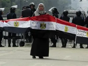 متظاهرة تمسك باعلام مصرية خلال احتجاج امام مجلس الشعب المصري
