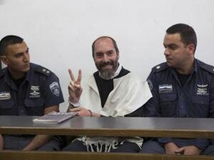 Israeli settler Yaakov Teitel flashes the "V" for victory sign prior to the start of his trial at the Jerusalem District Court on Tuesday. (Photo: AFP - Ahmad Gharabli)