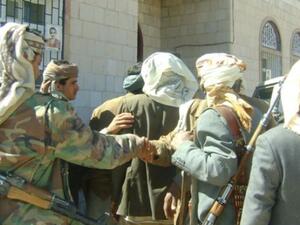 Armed Yemeni tribesmen lead a blindfolded abductee to an unidentified place. (Photo PressTV)