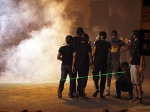 محتجون بحرينيون يضعون أقنعة واقية من الغاز أثناء اشتباكات مع الشرطة في قرية غربي المنامة